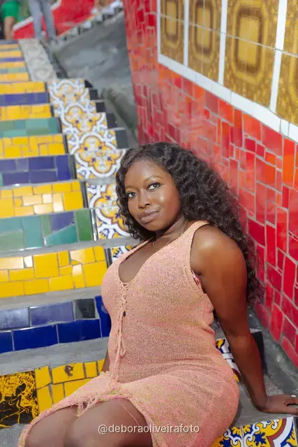 Mujer con vestido largo de crochet durazno sentada en la Escalinata Selarón de colores, en Río de Janeiro